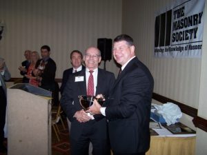 Dr. Porter (center) is congratulated by TMS Executive Director Phillip Samblanet after accepting the Scalzi Research Award from Dr. David I. McLean (back left).